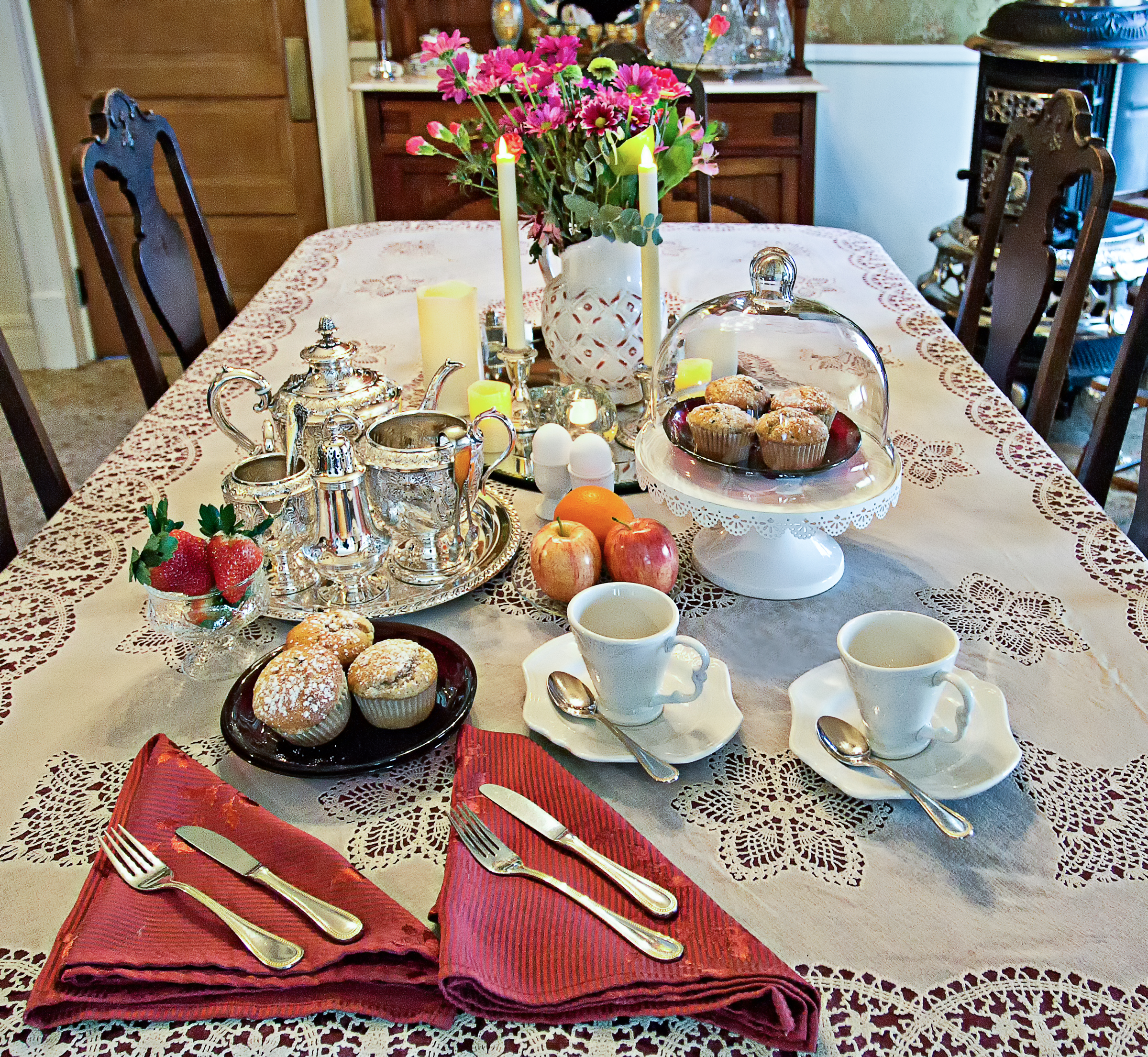 Picture of the breakfast table with food and flowers in the middle.